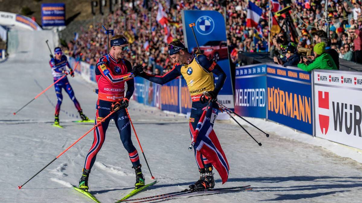 Johannes Thingnes Bö (left) congratulates compatriot Sturla Holm Laegreid