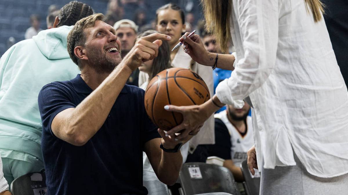 Dirk Nowitzki fulfills an autograph request from a female fan